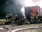Teilnehmer vor dem Brandcontainer